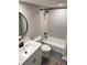 Well-lit bathroom featuring a modern tub, shower combo, and vanity with a sleek, black, round mirror at 30 Tads Trl, Oldsmar, FL 34677