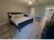 Comfortable bedroom with a ceiling fan and hardwood floors offers a relaxing view into the modern bath at 30 Tads Trl, Oldsmar, FL 34677