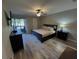 Cozy bedroom featuring a large window, ceiling fan, and hardwood floors with a decorative rug at 30 Tads Trl, Oldsmar, FL 34677