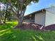 Backyard exterior featuring lanai, mature tree, and green lawn at 30 Tads Trl, Oldsmar, FL 34677