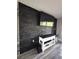 Modern living room featuring sleek black stone accent wall, and an entertainment center at 30 Tads Trl, Oldsmar, FL 34677