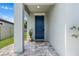 Charming front entrance with a blue door, stone walkway, and potted cactus at 30801 Parrot Reef Ct, Wesley Chapel, FL 33545