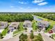 Aerial view of a charming single-story home near a lake and surrounded by lush landscaping at 30801 Parrot Reef Ct, Wesley Chapel, FL 33545
