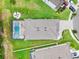 An aerial view of the property with a screened-in pool and spa, fire pit, and lush landscaping at 30801 Parrot Reef Ct, Wesley Chapel, FL 33545