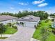 Aerial view of a charming single-story home with a well-manicured lawn and a brick-paved driveway at 30801 Parrot Reef Ct, Wesley Chapel, FL 33545