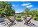 Scenic backyard with brick patio, fire pit, and expansive water view surrounded by lush greenery at 30801 Parrot Reef Ct, Wesley Chapel, FL 33545