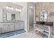 Elegant bathroom featuring double vanities, floral wallpaper, and neutral tones at 30801 Parrot Reef Ct, Wesley Chapel, FL 33545
