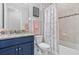 Updated bathroom featuring a granite vanity, floral shower curtain, and neutral tile work at 30801 Parrot Reef Ct, Wesley Chapel, FL 33545