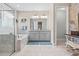 Elegant bathroom with a soaking tub, walk-in shower, dual vanities, and decorative wallpaper at 30801 Parrot Reef Ct, Wesley Chapel, FL 33545