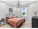 Charming bedroom with a stylish chandelier, comfortable bed, and a view from the window at 30801 Parrot Reef Ct, Wesley Chapel, FL 33545