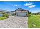 Charming single-story home with a well-manicured lawn and a brick-paved driveway at 30801 Parrot Reef Ct, Wesley Chapel, FL 33545