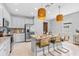 Bright kitchen with a center island featuring granite countertops, seating, stainless appliances, and pendant lighting at 30801 Parrot Reef Ct, Wesley Chapel, FL 33545