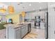 Bright kitchen featuring stainless appliances, gray cabinets, granite counters, and seamless flow to the living area at 30801 Parrot Reef Ct, Wesley Chapel, FL 33545