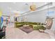 Bright, open-concept living room featuring a large green sectional and stylish hanging swing chair at 30801 Parrot Reef Ct, Wesley Chapel, FL 33545