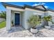 Beautiful home exterior featuring a blue front door, gray paint and manicured landscaping at 30801 Parrot Reef Ct, Wesley Chapel, FL 33545