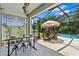 Inviting outdoor patio with dining area, comfortable seating, and a view of the pool and backyard at 30801 Parrot Reef Ct, Wesley Chapel, FL 33545