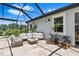 Comfortable screened-in patio with modern furniture and a serene outdoor living space at 30801 Parrot Reef Ct, Wesley Chapel, FL 33545