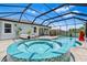 Beautiful screened-in pool and spa area with outdoor seating and lush landscaping at 30801 Parrot Reef Ct, Wesley Chapel, FL 33545