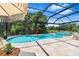 Stunning screened-in pool and spa with a travertine deck and scenic backyard views at 30801 Parrot Reef Ct, Wesley Chapel, FL 33545