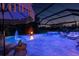 Wonderful screened-in pool and spa with colorful lights, outdoor seating, and tropical landscaping at 30801 Parrot Reef Ct, Wesley Chapel, FL 33545