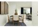 Bright dining area with a modern table, chairs, a rug, and an open view into the living area at 3436 Lapis Lake Dr, Zephyrhills, FL 33541