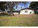 Back exterior view of a house with screened in patio and mature trees at 3705 Bruton, Plant City, FL 33565