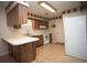 A compact kitchen featuring wood cabinets, white appliances, and a tile floor at 3705 Bruton, Plant City, FL 33565