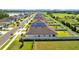 Aerial view of a neighborhood street showcasing well-maintained homes, green spaces, and a serene lake nearby at 3935 Capri Coast Dr, Plant City, FL 33565