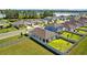 Aerial view highlighting a home with a fenced backyard and proximity to community amenities and a tranquil lake at 3935 Capri Coast Dr, Plant City, FL 33565