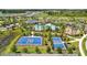 Aerial view of community amenities including a basketball court, tennis courts and a playground in a Florida neighborhood at 3935 Capri Coast Dr, Plant City, FL 33565