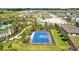 Aerial view of a community basketball court nestled within a residential area surrounded by lush greenery and palm trees at 3935 Capri Coast Dr, Plant City, FL 33565