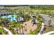 Aerial view of a community pool and playground surrounded by palm trees and walking paths in a Florida neighborhood at 3935 Capri Coast Dr, Plant City, FL 33565
