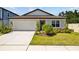 Charming single-story home with a well-manicured lawn, attached garage, and a welcoming front entrance at 3935 Capri Coast Dr, Plant City, FL 33565
