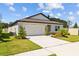 Charming single-story home with a well-manicured lawn, attached garage, and a welcoming front entrance at 3935 Capri Coast Dr, Plant City, FL 33565