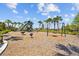 Playground in a community setting, featuring swings and a slide, offering children a space for outdoor play surrounded by palm trees at 3935 Capri Coast Dr, Plant City, FL 33565