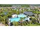 Aerial view of a sparkling community pool with palm trees, lounge areas, and a gazebo at 3935 Capri Coast Dr, Plant City, FL 33565