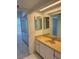 View of a bathroom showcasing a vanity with an attached mirror with a view of a bedroom and mirrored closet at 400 Island Way # 1402, Clearwater Beach, FL 33767