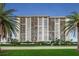 Stunning waterfront condo building featuring multiple balconies and lush landscaping with palm trees at 400 Island Way # 1402, Clearwater Beach, FL 33767