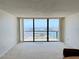 Spacious living room with large windows offering panoramic water views from this condo at 400 Island Way # 1402, Clearwater Beach, FL 33767