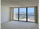 Bright living room with large windows offering panoramic water views from this condo at 400 Island Way # 1402, Clearwater Beach, FL 33767
