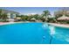 Bright blue swimming pool with a safety rope, surrounding buildings and lush landscaping at 400 Island Way # 1402, Clearwater Beach, FL 33767