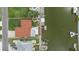 Aerial view of a home with a red roof and an outdoor seating area and dock with boat lift at 4299 Bellaire Dr, Hernando Beach, FL 34607