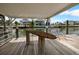 A covered boat dock includes a wood surfboard table and lift with waterfront views at 4299 Bellaire Dr, Hernando Beach, FL 34607