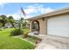 Inviting front entrance with an arched gate, a well-kept lawn, and lush tropical landscaping by the front door at 4299 Bellaire Dr, Hernando Beach, FL 34607