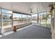 Enclosed screened porch offering views of the waterfront, with a thatched tiki hut in the distance at 4299 Bellaire Dr, Hernando Beach, FL 34607