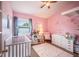 Adorable Bedroom with pink walls, cute decor, and natural light streaming through the window, perfect for a baby girl at 4314 La Mora Ct, Tampa, FL 33611