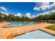 Community swimming pool with a brick deck, kiddie pool, lounge chairs, and mature landscaping at 4314 La Mora Ct, Tampa, FL 33611