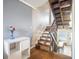 Open-concept design features wooden staircase complemented by hardwood floors and a modern white storage cabinet at 4314 La Mora Ct, Tampa, FL 33611