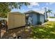 A backyard featuring a storage shed, a well-maintained lawn, and a variety of trees and plants at 4612 35Th E Ave, Palmetto, FL 34221