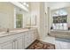 Elegant bathroom featuring double sinks, white cabinetry, bathtub, and a large arched window at 4612 35Th E Ave, Palmetto, FL 34221